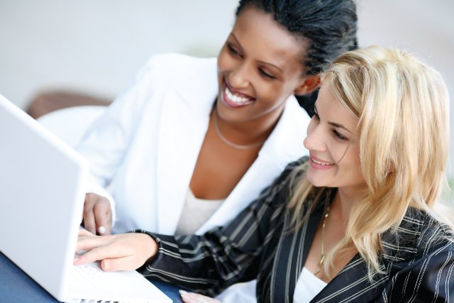 Twee professionals bekijken samen informatie op een laptop